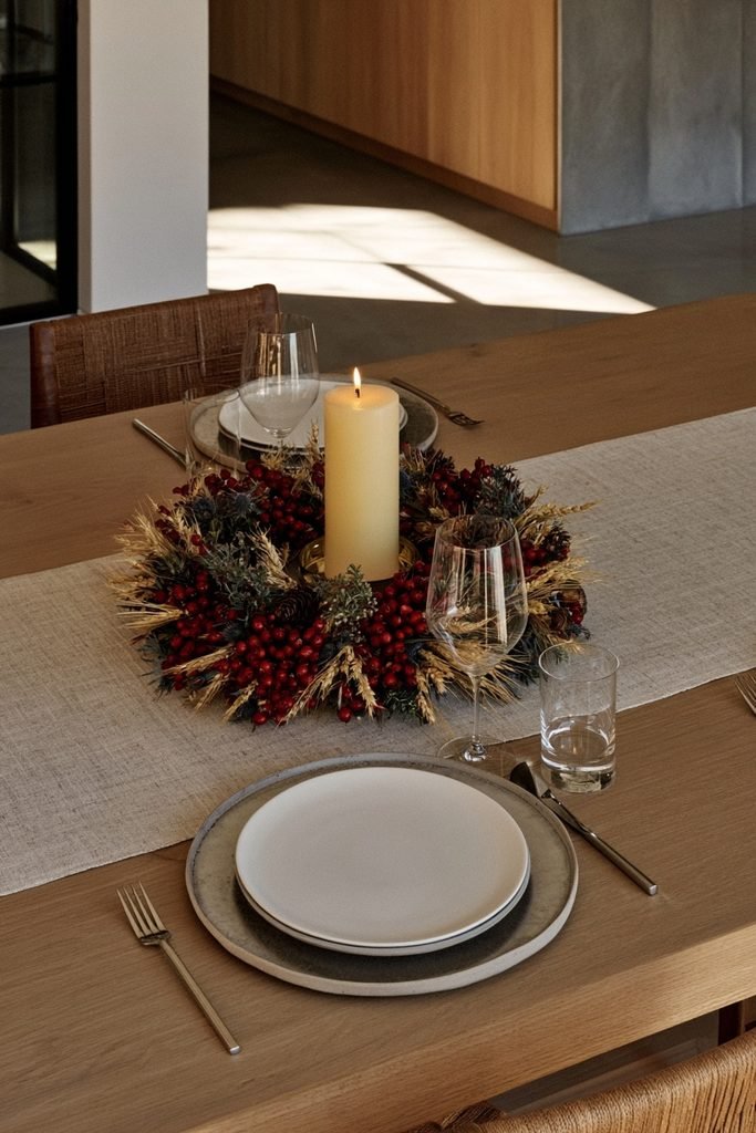 Berry and foliage candle ring wrapped around a pillar candle holder