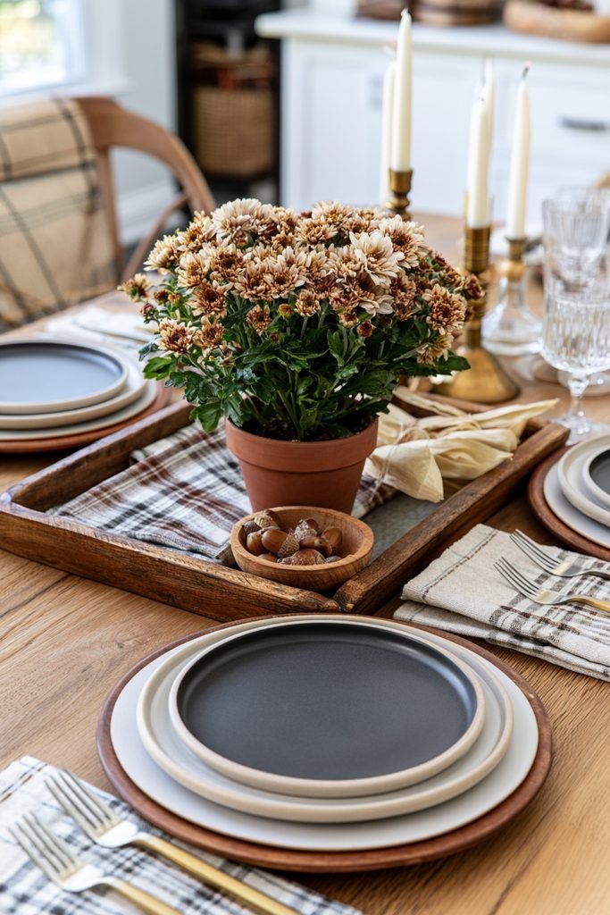 Small potted chrysanthemum styled on a rustic fall tray with plaid fabric and vintage garden shears.
