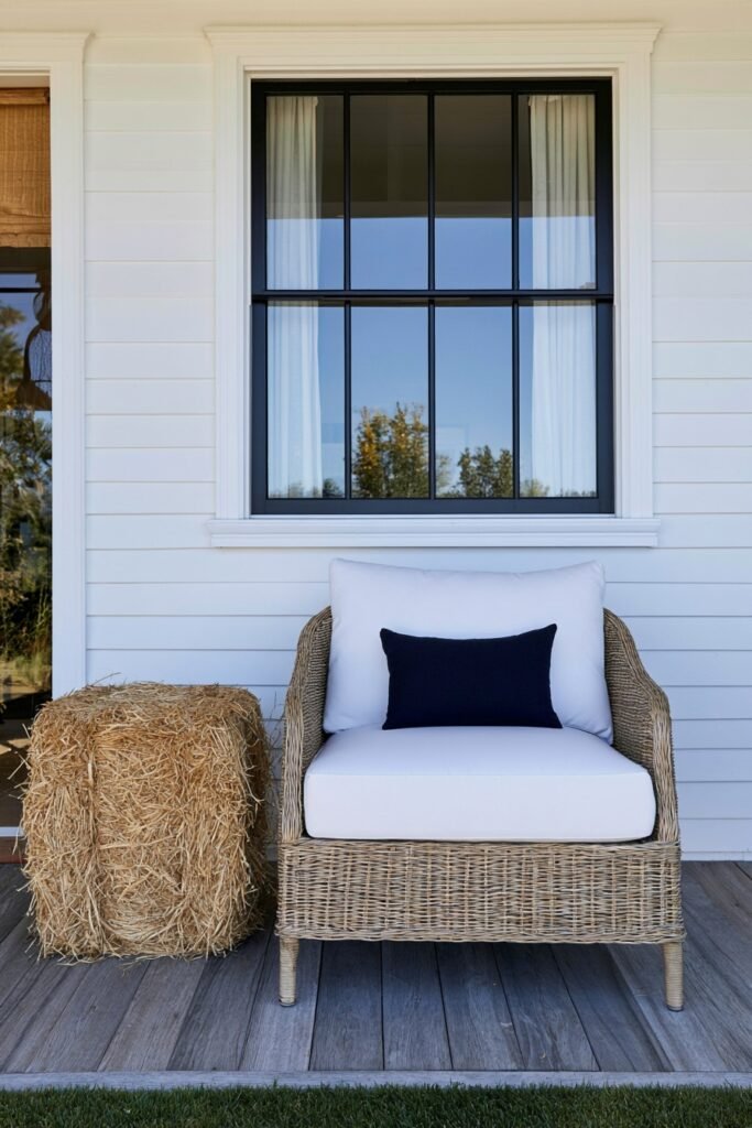 Farmhouse fall porch corner with a straw hay bale used as a side table