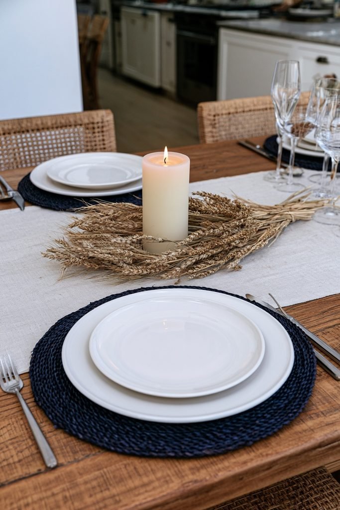 Dried wheat stalks bundled around a ceramic candle holder for fall