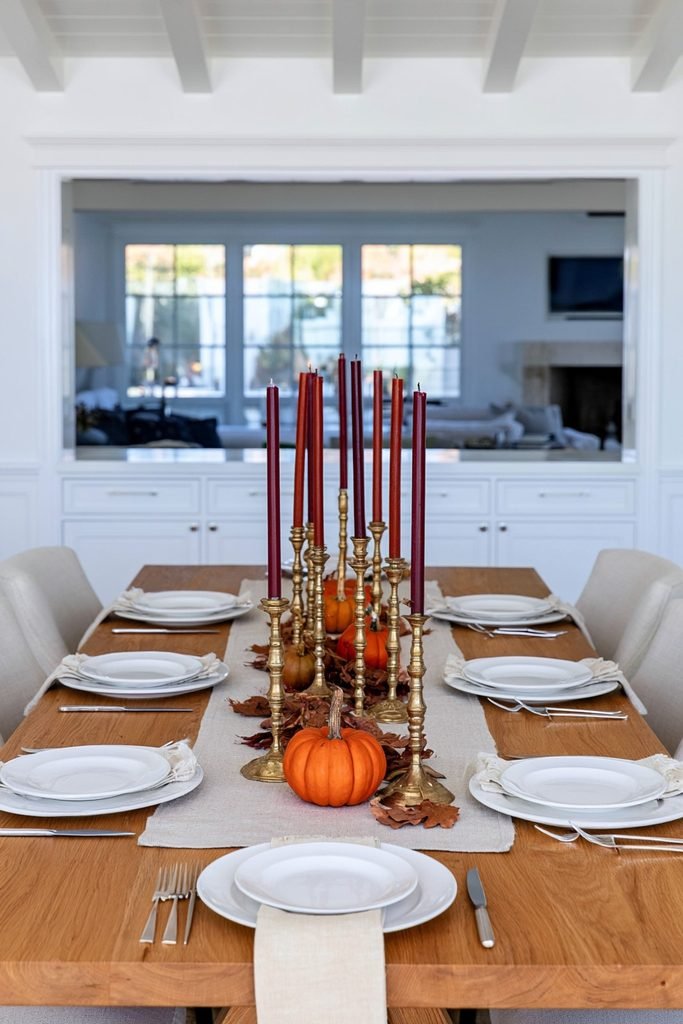 Vintage brass taper candle holders with burgundy candles on a fall dining table