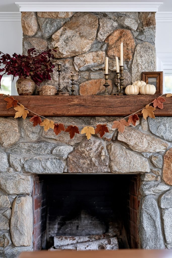 Rustic timber mantel decorated with a terracotta, mustard, and burnt orange felt leaf garland, pumpkins, and woven baskets.