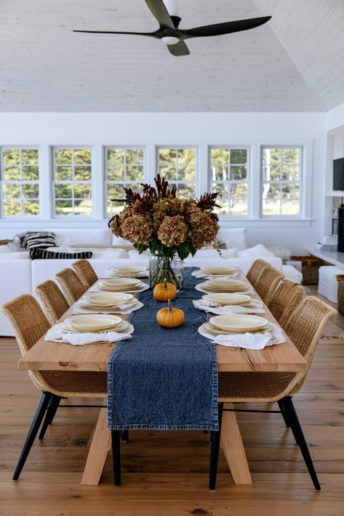 Single small pumpkin placed at each place setting on a dusty blue table runner