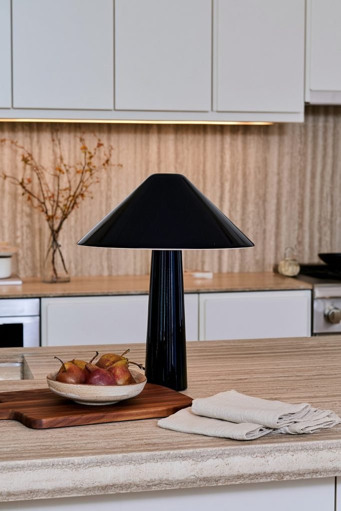 Brass cordless countertop lamp glowing on a modern dark kitchen counter