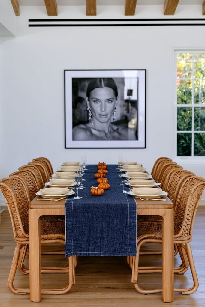 Modern farmhouse dining table with dusty blue linen and a burnt orange vase accent