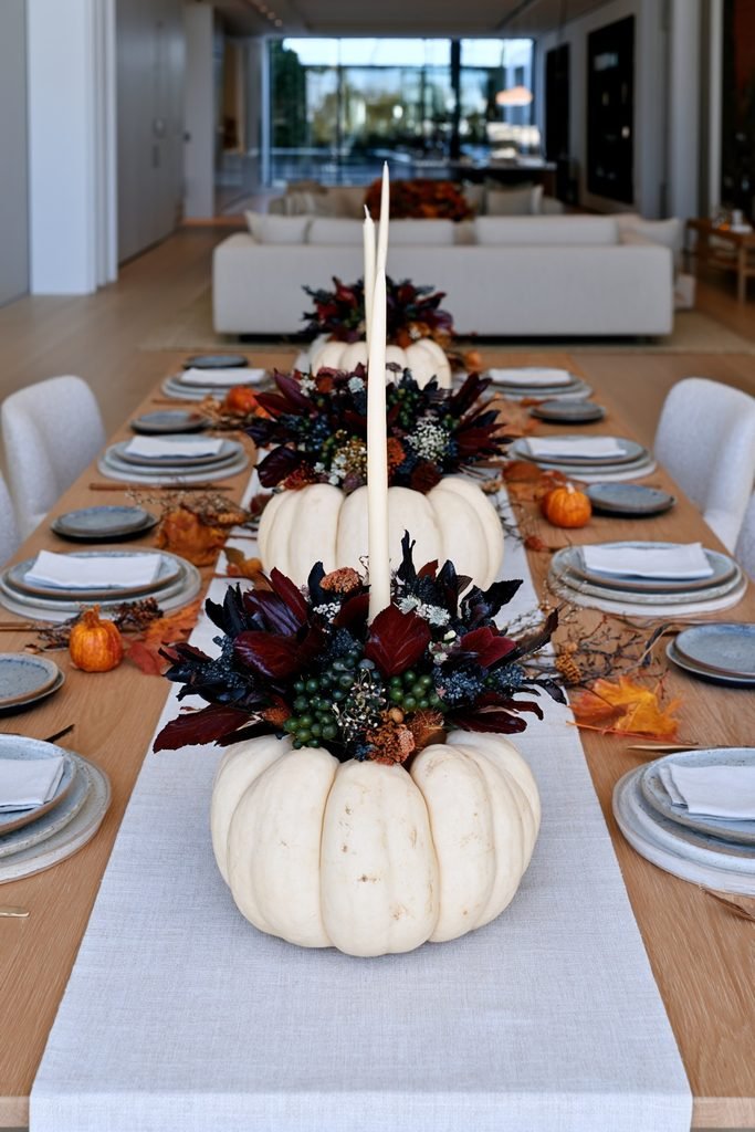 Ceramic pumpkin-shaped candlestick holding a taper candle on a fall dining table