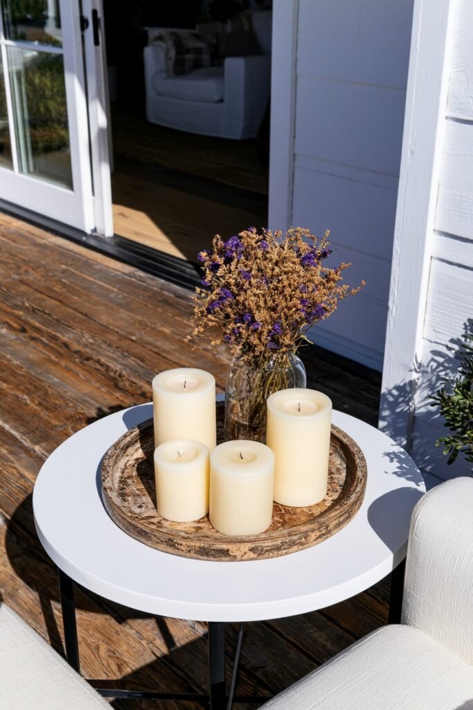 Farmhouse fall porch side table with a distressed wooden tray of candles and dried florals