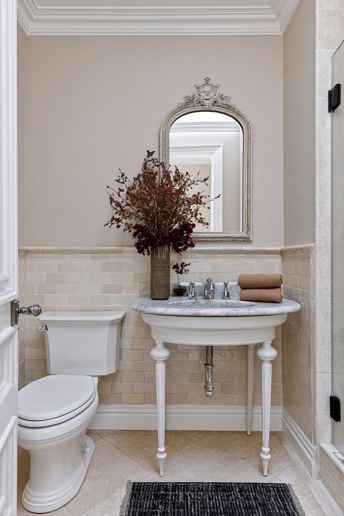 Small fall bathroom vanity decorated with dried autumn branches in a ceramic vase