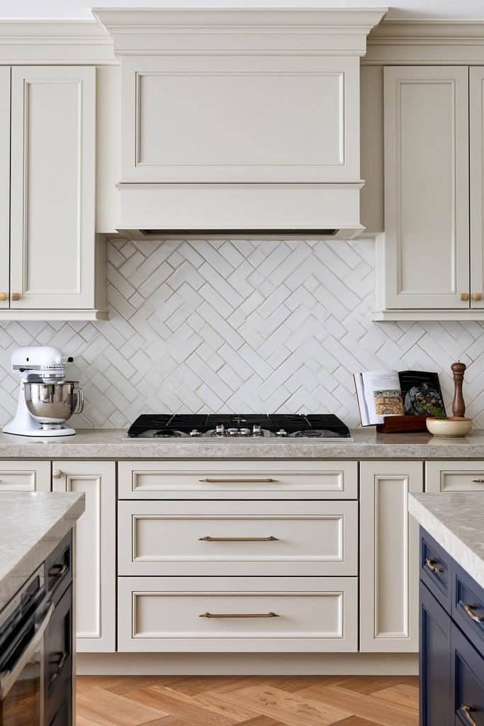 Elegant kitchen with a double herringbone backsplash pattern creating layered zigzag movement behind the countertop