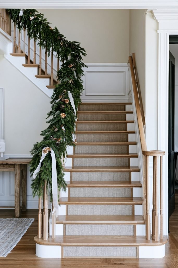 Mediterranean staircase decorated with dried orange slices, cinnamon sticks, and natural Christmas ornaments.