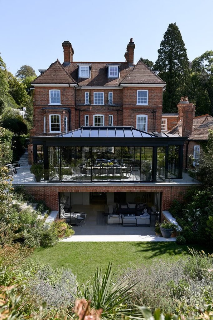 Large multi-level orangery extension with separate dining and lounge areas connected to a country house.
