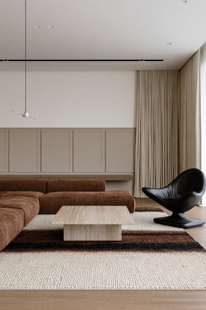Smooth flat-panel wainscoting in a minimalist contemporary bedroom with streamlined furniture and a neutral monochromatic color scheme
