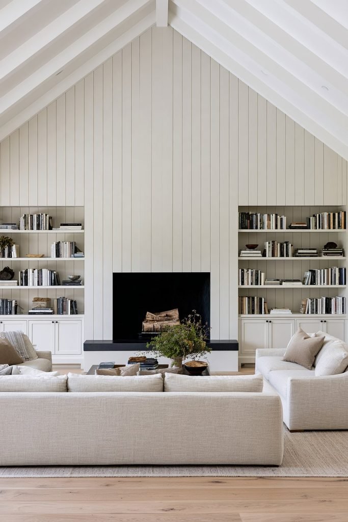 Floor-to-ceiling vertical shiplap fireplace wall with integrated oak cabinetry and built-in storage in a sophisticated living room.
