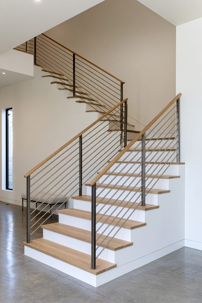 Modern staircase with horizontal steel cable railing and minimalist wood steps