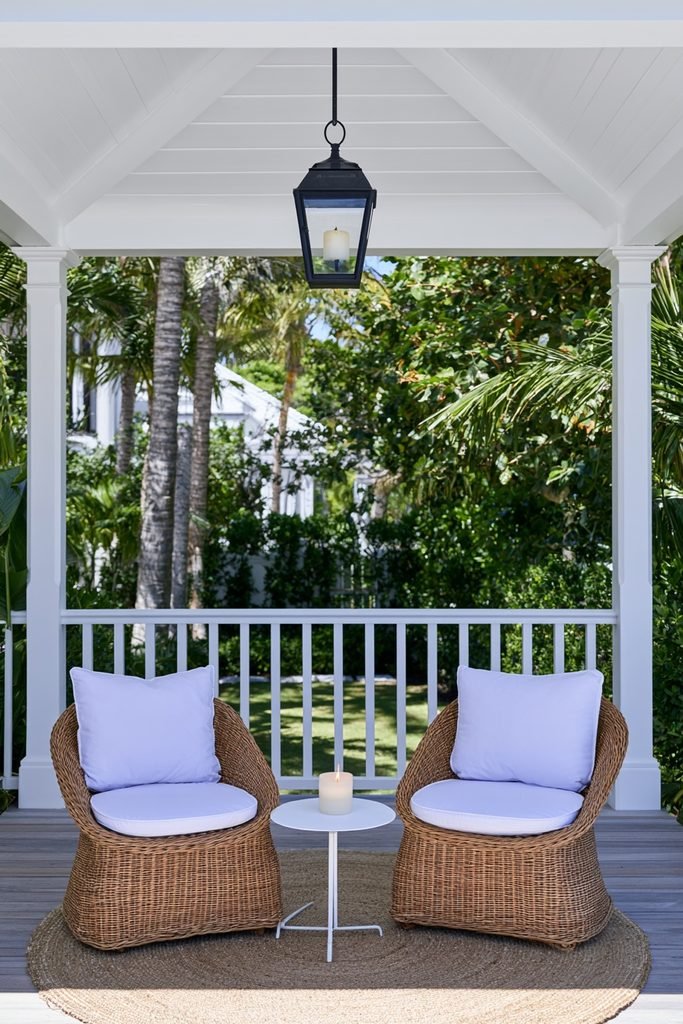 Hanging outdoor lanterns above a cozy covered front porch seating area
