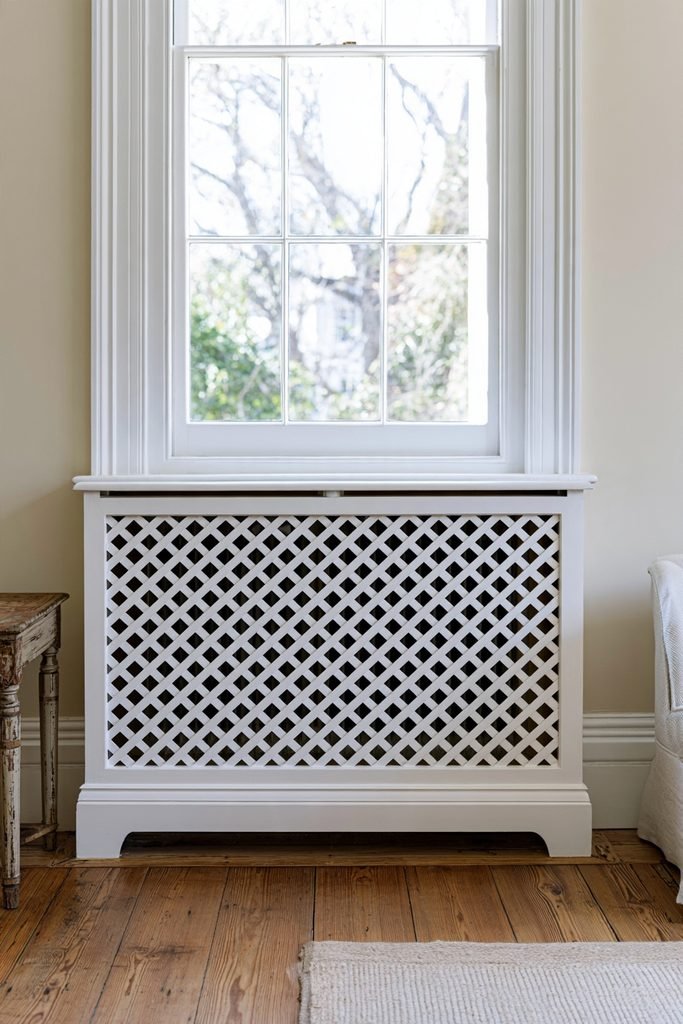 Traditional white lattice radiator cover with a decorative crisscross grille