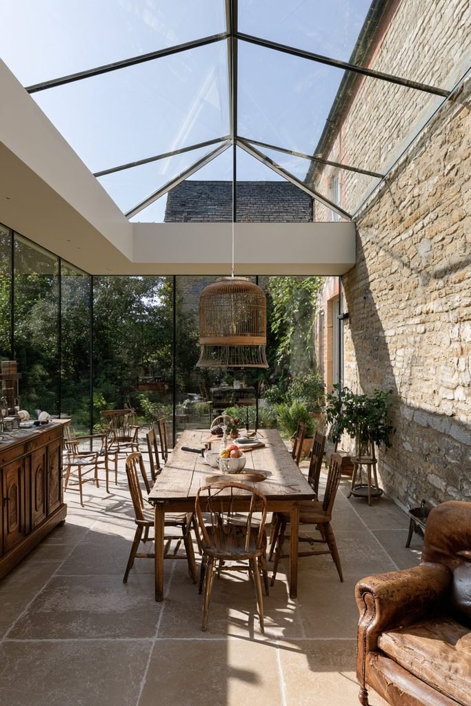 Characterful orangery featuring vintage furniture, antique accessories, and a traditional garden view.