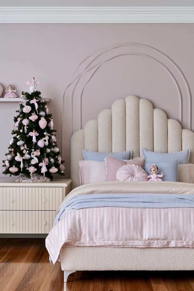 Pink ballerina and swan Christmas ornaments decorating a whimsical holiday bedroom tree