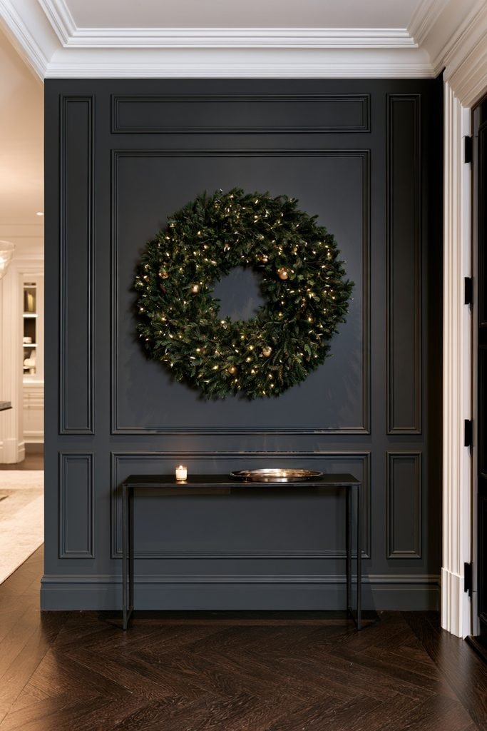 Christmas wreath decorated with warm string lights and gold accents for a New Year's Eve entryway