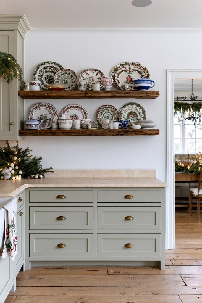 Christmas dishware displayed on open kitchen shelves with festive greenery