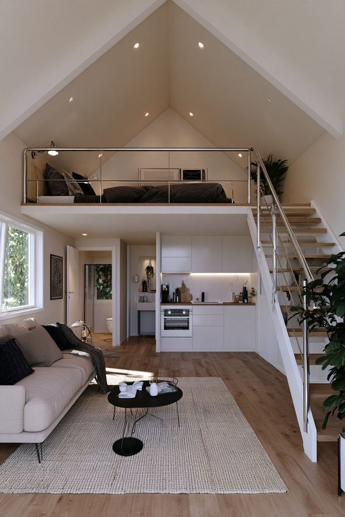 Small self-contained loft suite with compact bedroom, sitting area, kitchenette, bathroom, and sloped ceilings