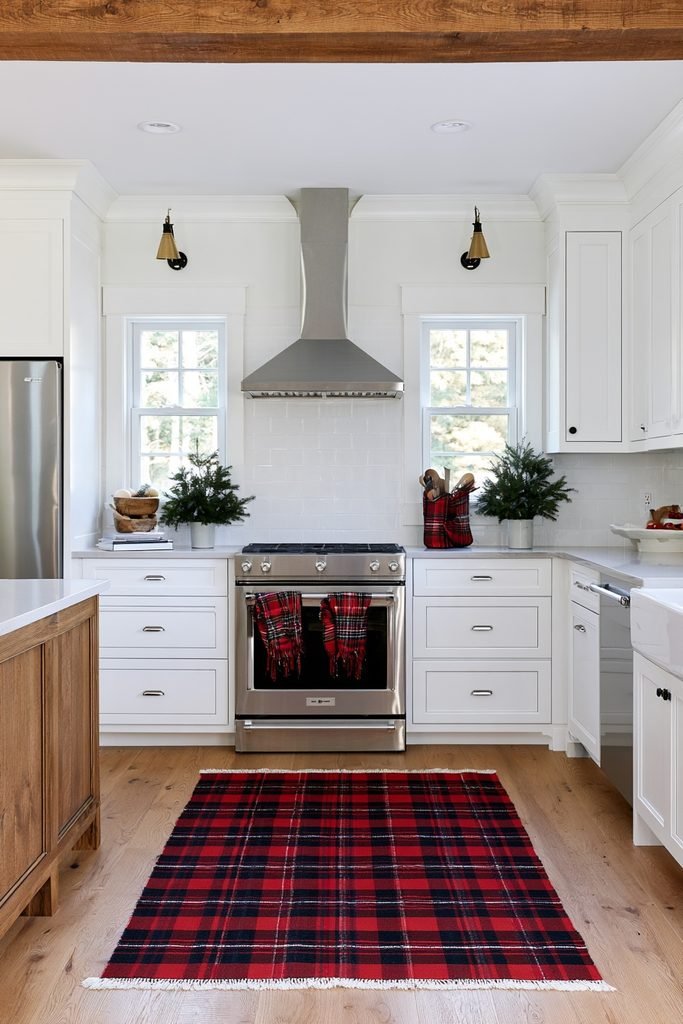 Buffalo plaid Christmas kitchen textiles with greenery and festive red accents