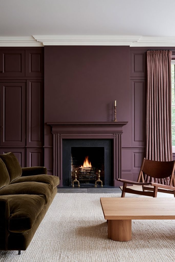 Muted plum colour-drenched living room with a matching fireplace surround, walls, ceiling, walnut furniture and brass accents