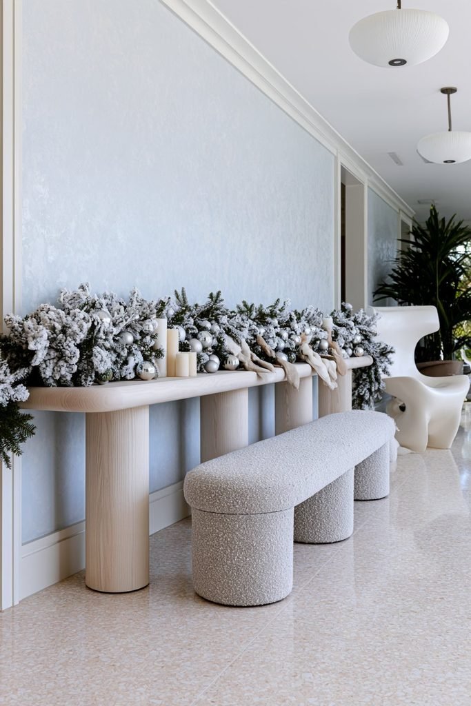 Flocked Christmas garland with snowy evergreen branches decorating a cozy holiday room