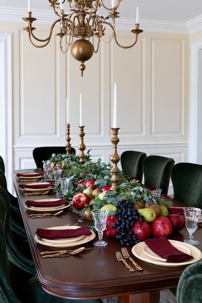 Thanksgiving dining table decorated with a harvest fruit garland of pears, apples, grapes, pomegranates, and eucalyptus foliage.