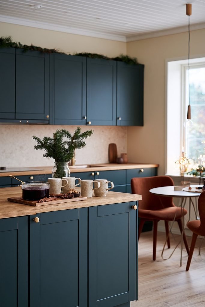Scandinavian Christmas drink station featuring ceramic mugs, a pot of spiced berry glögg, cinnamon sticks, and evergreen branches on an oak sideboard.