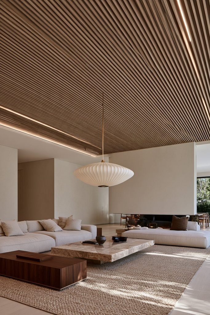 Full-height natural oak slat statement ceiling with integrated lighting in a warm Japandi living room
