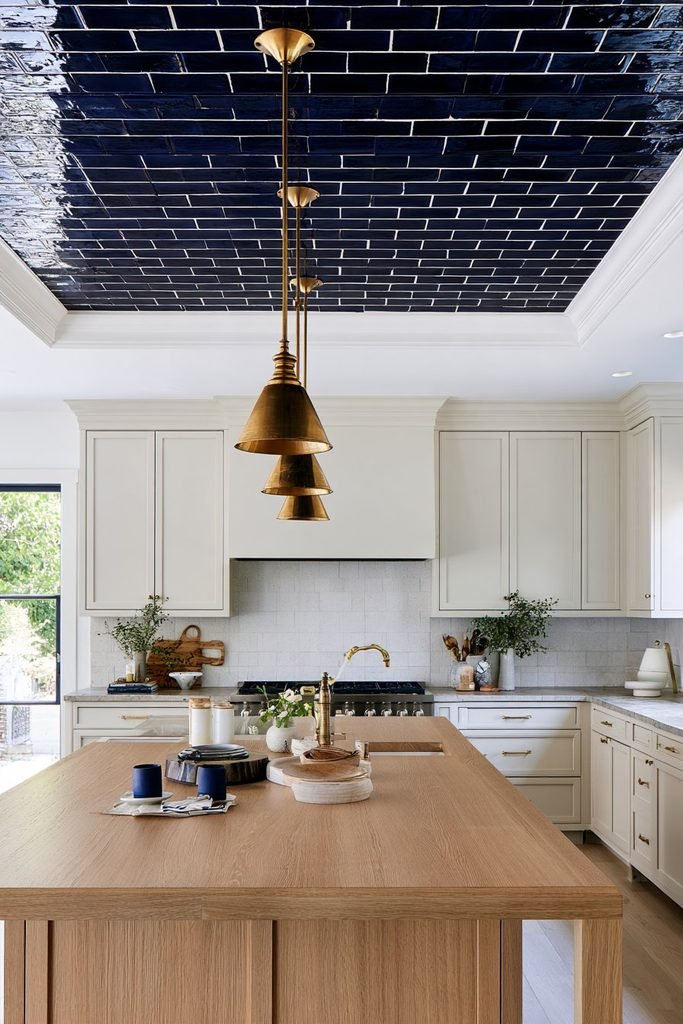 Blue glazed tile statement ceiling extending across a sophisticated kitchen above white cabinetry and island